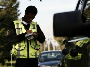 A parking enforcement officer writes a ticket.