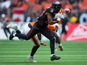 The ball bounces up off the turf as Ottawa Redblacks defensive back Brandyn Thompson defends against B.C. Lions wide receiver Shawn Gore during CFL action in Vancouver on September 13, 2015.