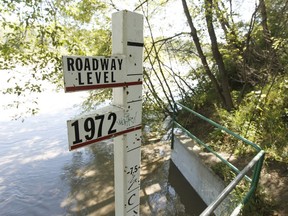 A metre stick showing the historic 1972 flood level is seen in Riverdale as water rises in the North Saskatchewan River in Edmonton, Alta., on Aug. 24, 2016.