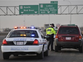 An Alberta Highway Patrol Sheriff hands out a speeding ticket to a motorist on the Queen Elizabeth II Highway south of Edmonton in this 2008 file photo.