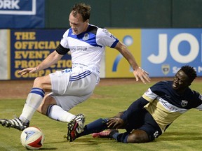 FC Edmonton captain Albert Watson, left, gets taken down by Jacksonville Armada FC forward Alhassane Keita in North American Soccer League play, Wednesday Sept 28, 2016 in Jacksonville, Florida.