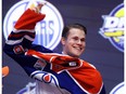 Jesse Puljujarvi puts on an Edmonton Oilers jersey after being selected fourth overall at the 2016 NHL Draft on June 24, 2016 in Buffalo, New York.