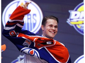 Jesse Puljujarvi puts on an Edmonton Oilers jersey after being selected fourth overall at the 2016 NHL Draft on June 24, 2016 in Buffalo, New York.
