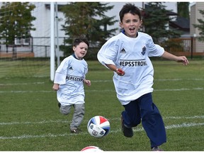 Brothers Gabe (right), 7, and Callen, 6, sons of EPS Const. Dan Woodall, who was killed in the line of duty in 2015, on the soccer pitch after the second Woodall Cup and First Responders Day was announced at Constable Dan Woodall Park in Edmonton Wednesday, Sept. 7, 2016.