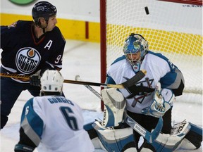 Edmonton Oilers winger Ryan Smyth, left, tips the puck high into the net past San Jose Sharks goalie Evgeni Nabokov during NHL action Thursday, Oct. 12, 2006, at Rexall Place. This was Smyth's second goal of the night and 500th NHL career point.