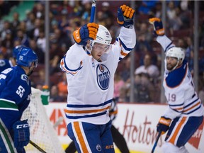 Edmonton Oilers' Drake Caggiula, centre, and Patrick Maroon, back right, celebrate Caggiula's goal against Vancouver Canucks' goalie Ryan Miller, back left, during the first period of a pre-season NHL hockey game in Vancouver, B.C., on Wednesday September 28, 2016.