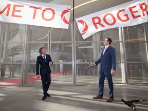 Oilers owner Daryl Katz and then-mayor Don Iveson pull the banner down during the grand opening of Rogers Place in Edmonton on Sept. 8, 2016. The team and the city collaborated on the project with virtually no help from the provincial government.