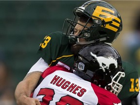 Edmonton Eskimos quarterback Mike Reilly (13) gets hit by Calgary Stampeders Charleston Hughes (39) on Saturday, September 10, 2016 in Edmonton. Greg  Southam / Postmedia  (To go with sports story) Photos for stories, columns off Eskimos game appearing in Sunday, Sept. 11 edition.