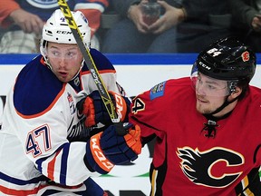 Calgary Flames' Rasmus Andersson (54) grapples with Edmonton Oilers' Joey Benik (47) during first period 2016 NHL Young Stars Classic action at the South Okanagan Events Centre in Penticton, B.C., on Sept. 17, 2016.