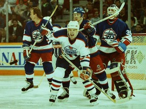 Edmonton Oilers centre Mark Lamb stands in front of the Winnipeg Jets goal in this undated photo from the early 1990s, with from left behind him, Jets defencemen Randy Carlyle and Phil Housley, and goalie Bob Essensa.