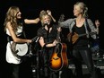 Emily Robison, left, and Martie Maguire, right, adjust Natalie Maines's hair as the Dixie Chicks perform at the Nokia Theatre in Los Angeles.