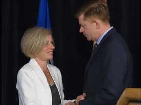 Premier Rachel Notley shakes hands on May 18, 2016, with leader of the opposition and Wildrose MLA for Fort McMurray-Conklin Brian Jean, during a press conference at the Provincial Operations Centre in Edmonton while the city was evacuated due to a massive wildfire.