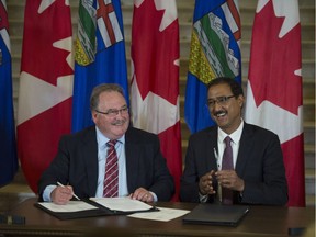 From left, Brian Mason, Alberta minister of infrastructure, and  Amarjeet Sohi, federal minister of infrastructure and communities, sign the agreement. Three levels of government were on hand for the announcement a new federal-provincial agreement on water, wastewater and transit projects. on Sept.1, 2016.