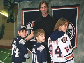 Ryan Smyth fans, from left to right, Braeden Caruk, 6, Brendan Megaw, 5 and Ashley Megaw, 9, pose with their favourite player, Ryan Smyth, on Oct. 21, 2002, at Edmonton's Kinsmen Sports Centre.