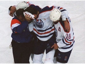 Edmonton Oilers teammates help centre Jason Arnott off the ice after his horrifying injury against the Detroit Red Wings on Oct. 8, 1995, at Edmonton Coliseum.