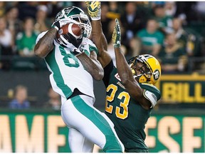 Saskatchewan Roughriders' Naaman Roosevelt (82) is tackled Edmonton Eskimos' Marcell Young (23) during second half CFL football action in Edmonton on Friday, August 26, 2016.