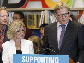 Alberta Premier Rachel Notley (left) listens as Education Minister David Eggen answers a question about LGBTQ policies at the opening of Nellie Carlson School, a brand new K-9 school, in Edmonton, on Thursday, Sept. 1, 2016.