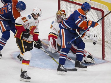 The Edmonton Oilers' Tyler Pitlick (15) scores on the Calgary Flames' goaltender Jon Gillies (32) during third period pre-season NHL action at Rogers Place, in Edmonton on Monday Sept. 26, 2016. Tyler Beck (45) is pictured left.