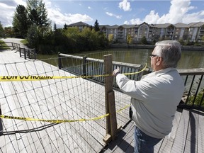 Resident Ed Rasko looks over a fenced off waterside walkway at Beaumaris Lake in north Edmonton, Alberta on Friday, September 9, 2016. Residents say the  City of Edmonton has neglected maintenance in infrastructure surrounding the stormwater pond.