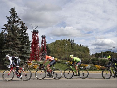 Riders in the peloton race past oil derricks in stage 3 of the Tour of Alberta in Drayton Valley, Alta., on Sept. 3, 2016.