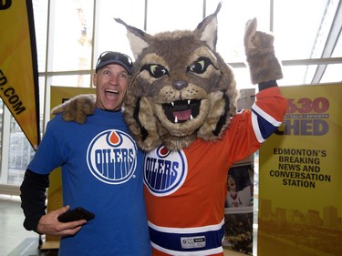 An Edmonton Oiler fan poses for a photo with the Edmonton Oiler's new mascot Hunter the Canadian Lynx, in Edmonton on Monday Sept. 26, 2016.