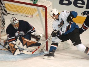 Washington Capitals centre Boyd Gordon, right, zeroes in on Edmonton Oilers goalie Dwayne Roloson during NHL action at Rexall Place on Oct. 28, 2006.