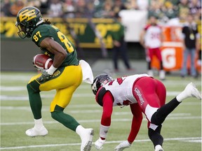 Calgary Stampeders Tommie Campbell (25) tries to stop Edmonton Eskimos Derel Walker (87) as he makes the interception for a touchdown during first half CFL action in Edmonton, Alta., on Saturday September 10, 2016.