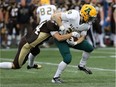 University of Manitoba Bisons HB Cam Teschuk grabs at the ball carried by University of Alberta Golden Bears RB Alex Bradley during Canada West football action in Winnipeg on Fri., Sept. 16, 2016.