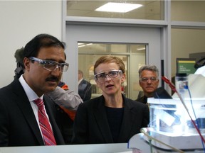 University of Alberta chemistry professor Jillian Buriak demonstrates to federal Infrastructure Minister Amarjeet Sohi a device that uses energy from the sun to split water into clean-burning hydrogen fuel.