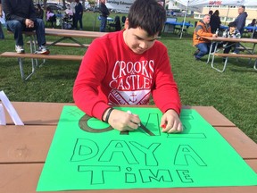 Arron Sharphead, 23, works on a poster at Recover Day Edmonton, Sunday, Sept. 18. The annual event is to bring awareness and counter stigma for people recovering from addictions and to help connect people with relevant services.