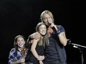 Keith Urban and a young fan, St. Albert's Hailey Benedict, who he pulled on stage.