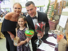 Krista and Andrew Ference, co-hosts at the Royal Alexandra Hospital Foundation's Harvest Celebration, with nine-year-old Emily Alexander.