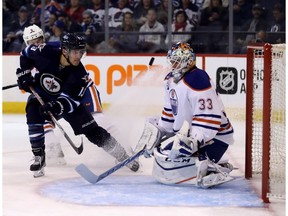 Winnipeg Jets' Brandon Tanev (13) fires the puck on Edmonton Oilers goaltender Cam Talbot (33) with Adam Larsson (6) trailing during second period pre-season NHL hockey in Winnipeg, Friday, September 30, 2016.