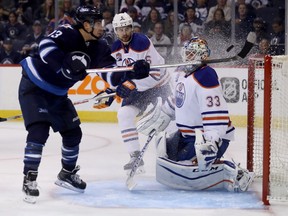 Winnipeg Jets' Brandon Tanev (13) knocks the puck into the net behind Edmonton Oilers' goaltender Cam Talbot (33) with Adam Larsson (6) trailing but the goal was waived off due to a high stick during second period pres-eason NHL hockey in Winnipeg, Friday, September 30, 2016.