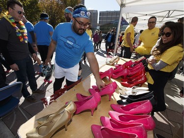 NAIT team members pick their shoes up during YWCA Edmonton's Walk A Mile In Her Shoes  in Edmonton, Alberta on Wednesday, September 21, 2016. Over $200,000 was raised for YWCA violence prevention and recovery programs.