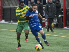 Pedro Galvao of FC Edmonton, right, is held back by Darnell Kings of the Tampa Bay Rowdies at Clarke Field in Edmonton on October 9, 2016. FC Edmonton won 1-0 and clinched a spot in the NASL playoffs.