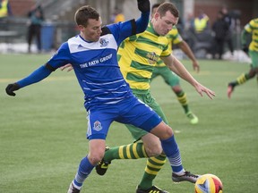 Ben Fisk of FC Edmonton, left, maintains possession from Neill Collins of the Tampa Bay Rowdies at Clarke Field in Edmonton on October 9, 2016.