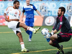 Edmonton's keeper Matt VanOekel, right, makes a save against Carolina's Jonathan Orlando, left, during NASL soccer action between FC Edmonton and the Carolina RailHawks at Clarke Stadium in Edmonton, Alta., on Sunday, July 31, 2016.