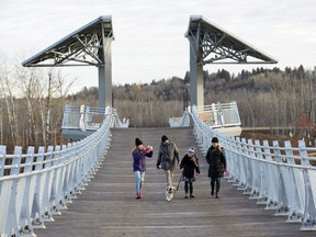 Edmontonians walk across the newly opened Terwillegar Park footbridge, in Edmonton on Oct. 21, 2016. The 262-metre long "stressed ribbon" bridge connects Terwillegar Park to the Oleskiw trails on the north side of the North Saskatchewan River.