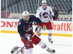 Mark Scheifele, left, of the Winnipeg Jets shoots from his knees during practice in preparation for the 2016 Tim Hortons NHL Heritage Classic alumni hockey game on October 22, 2016 at Investors Group Field in Winnipeg, Manitoba.