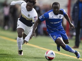 FC Edmonton Johann Smith is tripped up by Jacksonville Armada FC Charles Eloundou at Clarke Field on Sunday, October 23, 2016 in Edmonton.