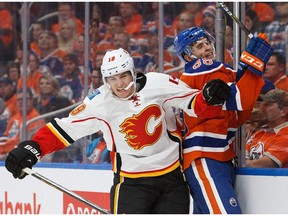 EDMONTON, AB - OCTOBER 12:  Brandon Davidson #88 of the Edmonton Oilers is taken to the boards by Matthew Tkachuk #19 of the Calgary Flames on October 12, 2016 at Rogers Place.
