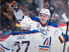 Edmonton Oilers' Connor McDavid, back, and Milan Lucic celebrate McDavid's goal against the Vancouver Canucks during the second period of an NHL hockey game in Vancouver, B.C., on Friday October 28, 2016.