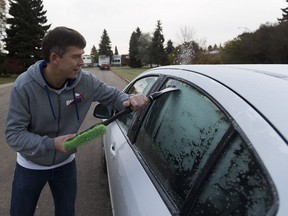 Dmitriy Lapshin scrapes the the windows of his car as the temperature dipped below 0C overnight on Thursday, October 6, 2016 in Edmonton.