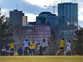 A soccer match in Forest Heights Park with the city skyline in the background.