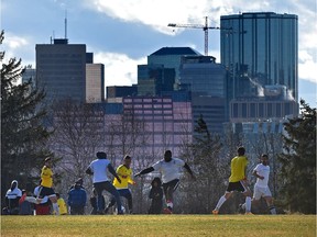 A soccer match takes place in Forest Heights Park with the city skyline in the background.