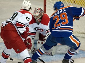 Hurricanes goalie Cam Ward makes a save with Leon Draisaitl and Victor Rask in front as the Carolina Hurricanes play the Edmonton Oilers in Edmonton, January 4, 2016.