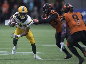 Edmonton Eskimos wide receiver Derel Walker (87) gets tackled by BC Lions defensive back Anthony Gaitor (23) and Brandon Stewart (9) during CFL football action, in Vancouver on Saturday, Oct. 22, 2016.