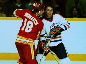 Edmonton Oilers forward Dave Lumley, right, tangles with Calgary Flames forward Dave Hindmarch in early 1980s NHL action.