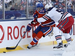 Edmonton Oilers' Leon Draisaitl (29) and Winnipeg Jets' Tyler Myers (57) go for the puck in Jets' territory during first period NHL Heritage Classic action in Winnipeg on Sunday, October 23, 2016.